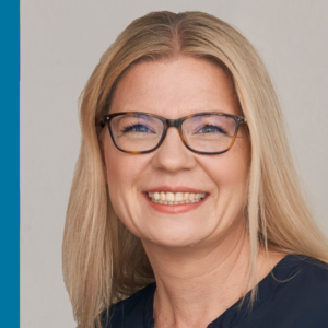 Person mit Brille und blonden Haaren vor hellem Hintergrund.