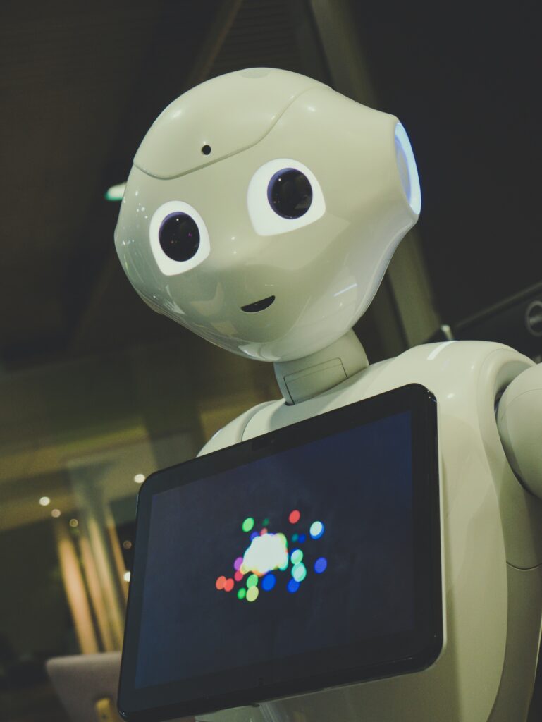 Humanoider Roboter mit Display als Sinnbild für den Einsatz von Künstlicher Intelligenz zur Unterstützung neurodiverser Menschen in Alltag, Kommunikation und Organisation.