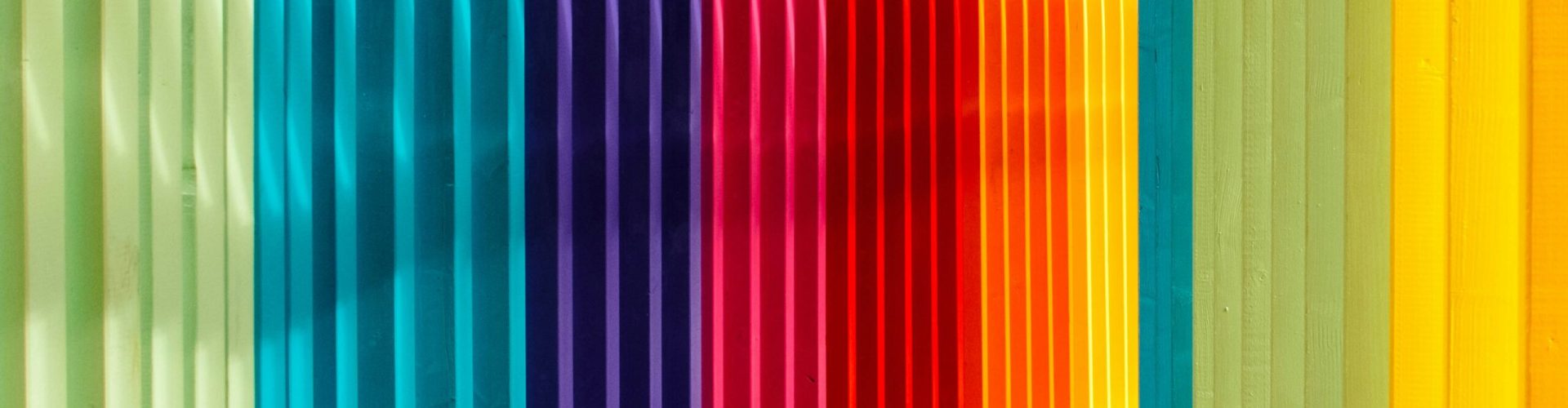 Farbenfroher Tunnel aus geometrischen Rahmen in Regenbogenfarben als Symbol für Neurodiversität, unterschiedliche Denkweisen und die unterstützenden Möglichkeiten von Künstlicher Intelligenz.